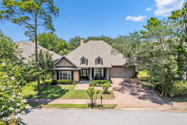 134 Mussett Bayou Ct, Santa Rosa Beach, FL 32459 - view of front of house with an attached garage, decorative driveway, a chimney, and a front yard