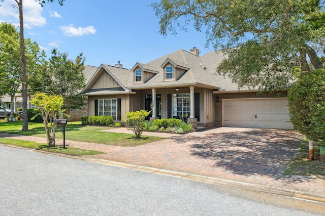 134 Mussett Bayou Ct, Santa Rosa Beach, FL 32459 - view of front of home featuring a chimney, board and batten siding, an attached garage, decorative driveway, and a front yard