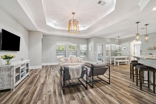 134 Mussett Bayou Ct, Santa Rosa Beach, FL 32459 - living room featuring a raised ceiling, crown molding, dark wood-style floors, and a chandelier