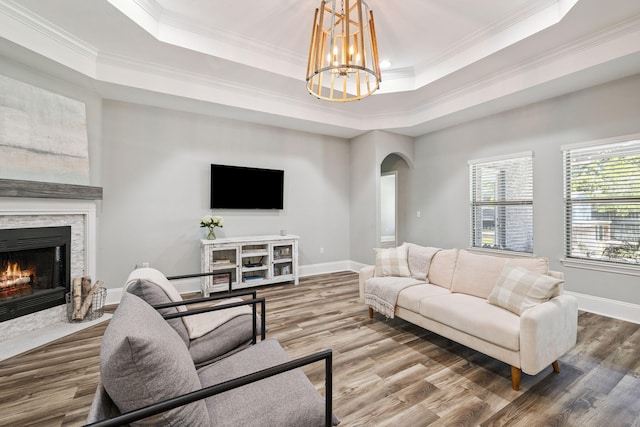 134 Mussett Bayou Ct, Santa Rosa Beach, FL 32459 - living room featuring arched walkways, a raised ceiling, crown molding, a fireplace, and wood finished floors