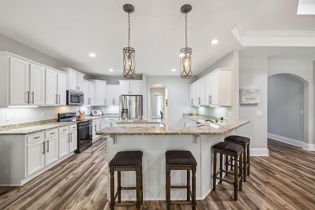 134 Mussett Bayou Ct, Santa Rosa Beach, FL 32459 - kitchen with appliances with stainless steel finishes, arched walkways, dark wood-style flooring, a breakfast bar, and white cabinetry
