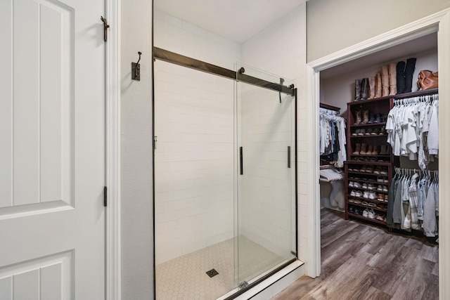 134 Mussett Bayou Ct, Santa Rosa Beach, FL 32459 - full bathroom with a stall shower, a walk in closet, and wood finished floors