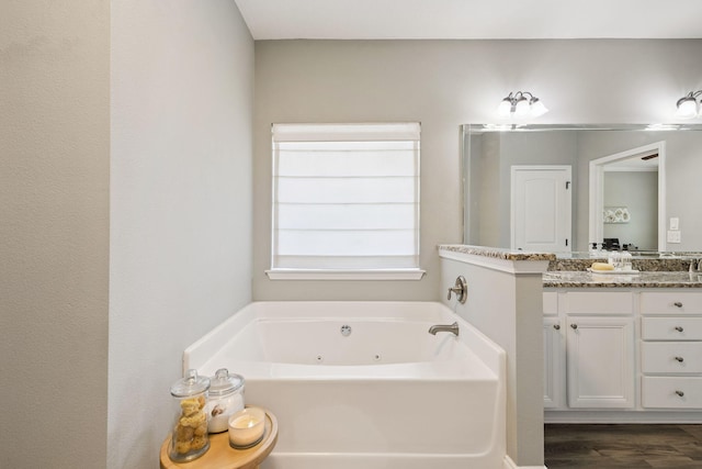 134 Mussett Bayou Ct, Santa Rosa Beach, FL 32459 - bathroom with vanity, a jetted tub, and wood finished floors