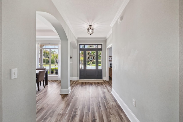 134 Mussett Bayou Ct, Santa Rosa Beach, FL 32459 - entryway featuring a chandelier, wood finished floors, ornamental molding, a textured wall, and arched walkways