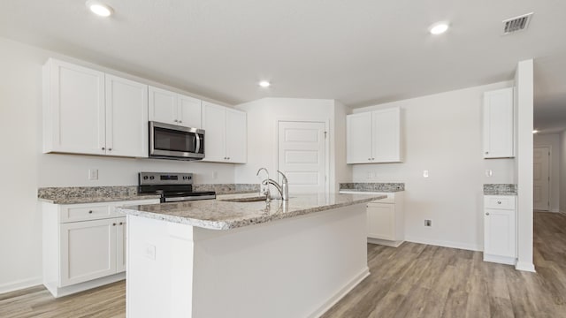207 Eunola Ln, Freeport, FL 32439 - kitchen featuring appliances with stainless steel finishes, light wood-type flooring, an island with sink, recessed lighting, and white cabinets