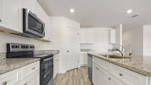 207 Eunola Ln, Freeport, FL 32439 - kitchen featuring stainless steel appliances, light wood finished floors, white cabinetry, light stone countertops, and recessed lighting