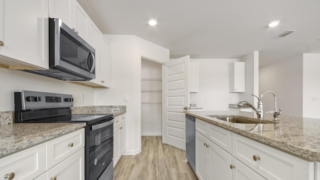 207 Eunola Ln, Freeport, FL 32439 - kitchen with stainless steel appliances, light wood finished floors, white cabinetry, light stone counters, and recessed lighting