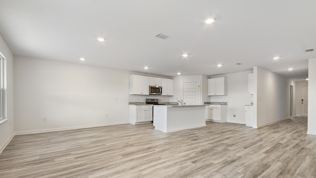 207 Eunola Ln, Freeport, FL 32439 - kitchen featuring appliances with stainless steel finishes, open floor plan, light wood-type flooring, white cabinets, and a center island with sink