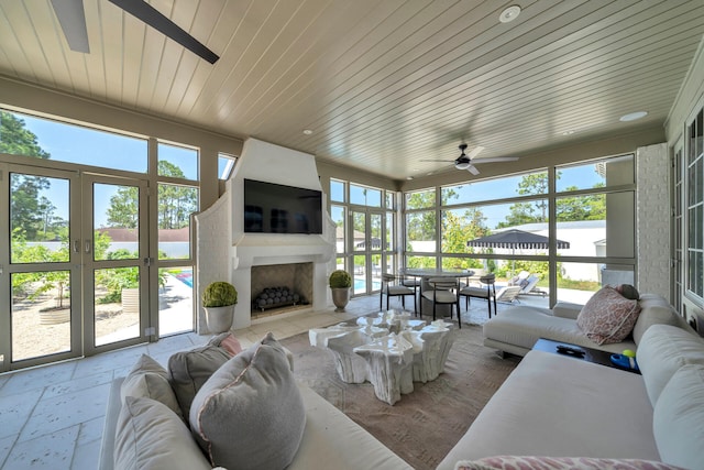 34 E Surfside Dr, Santa Rosa Beach, FL 32459 - sunroom with an outdoor living space with a fireplace, a ceiling fan, and plenty of natural light