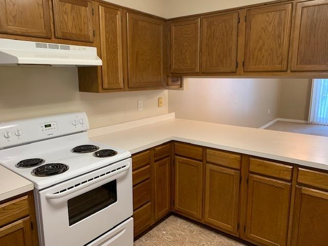 507 Chinas Cv Unit C, Fort Walton Beach, FL 32547 - kitchen featuring white electric range, under cabinet range hood, light countertops, and brown cabinetry