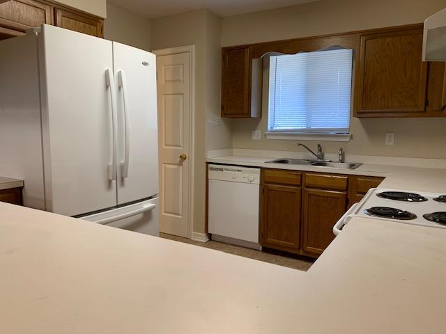 507 Chinas Cv Unit C, Fort Walton Beach, FL 32547 - kitchen with white appliances, brown cabinetry, light countertops, and exhaust hood