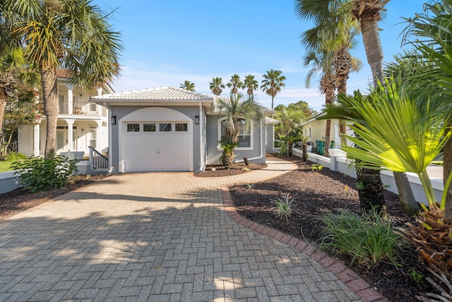 94 Terra Cotta Way, Destin, FL 32541 - mediterranean / spanish home featuring an attached garage, decorative driveway, stucco siding, and a tile roof