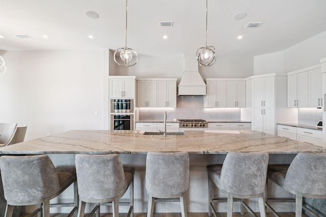 31 Driftwood Ct, Santa Rosa Beach, FL 32459 - kitchen with premium range hood, backsplash, white cabinetry, and recessed lighting