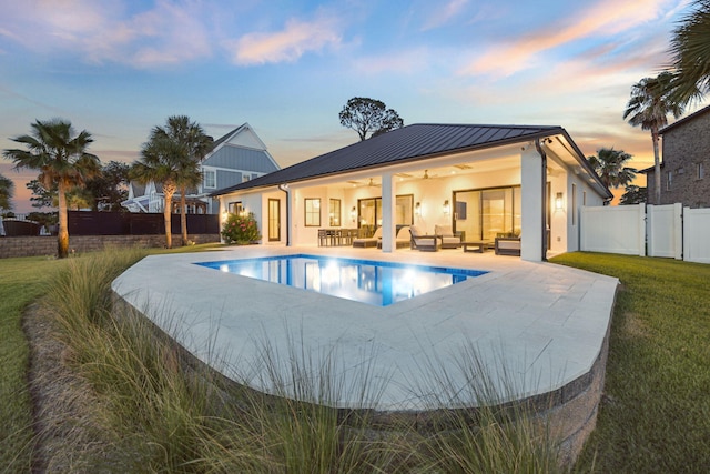 31 Driftwood Ct, Santa Rosa Beach, FL 32459 - back of house at dusk with an outdoor living space, ceiling fan, a patio, a standing seam roof, and stucco siding