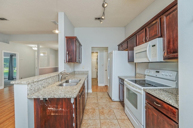 8562 Vehlin Ct, Navarre, FL 32566 - kitchen featuring white appliances, a peninsula, dark brown cabinets, and a textured ceiling