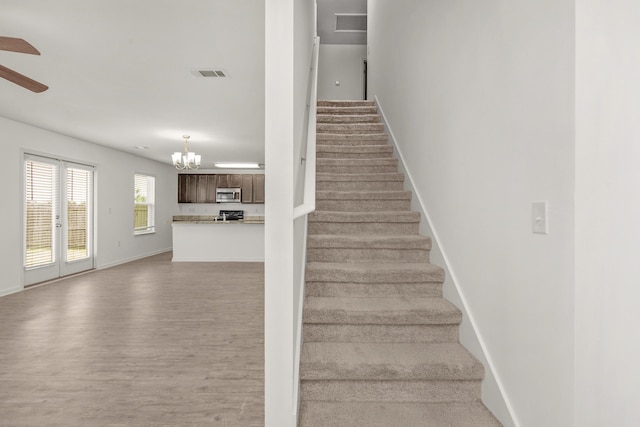 718 Widgeon Way, Crestview, FL 32539 - stairs with wood finished floors, a chandelier, and ceiling fan
