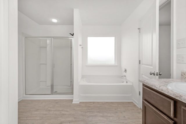 718 Widgeon Way, Crestview, FL 32539 - bathroom featuring a stall shower, wood finished floors, a bath, and vanity