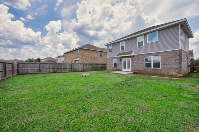 718 Widgeon Way, Crestview, FL 32539 - back of house featuring a fire pit, a fenced backyard, brick siding, and french doors