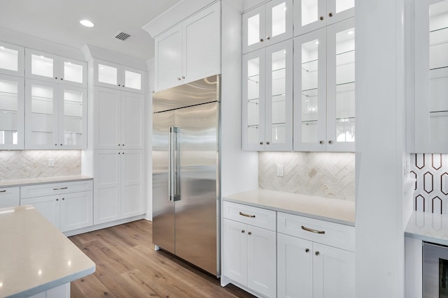 314 W Firethorn Cir Lot 33, Watersound, FL 32461 - kitchen featuring stainless steel built in refrigerator, white cabinetry, backsplash, light wood-type flooring, and wine cooler