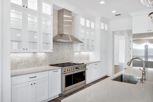 314 W Firethorn Cir Lot 33, Watersound, FL 32461 - kitchen with high end appliances, wall chimney exhaust hood, white cabinets, dark wood-type flooring, and decorative backsplash