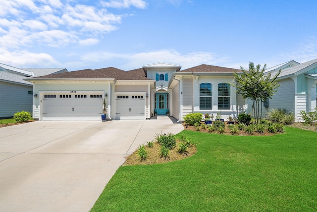 8324 Fins Up Ct, Panama City Beach, FL 32413 - view of front of house featuring a garage, driveway, and a front yard