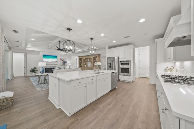 8324 Fins Up Ct, Panama City Beach, FL 32413 - kitchen with stainless steel appliances, custom exhaust hood, recessed lighting, a fireplace, and an island with sink