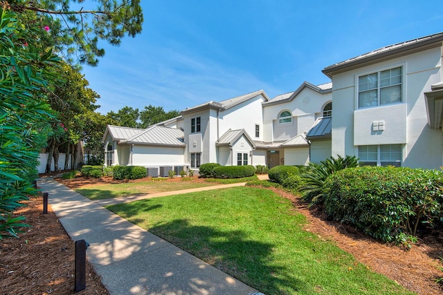 961 Northshore Dr, Miramar Beach, FL 32550 - view of front facade with stucco siding, a standing seam roof, a front yard, a metal roof, and a residential view
