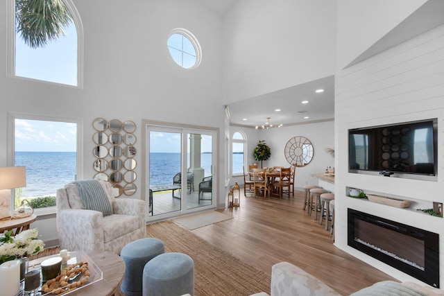 961 Northshore Dr, Miramar Beach, FL 32550 - living area with a towering ceiling, wood finished floors, healthy amount of natural light, a glass covered fireplace, and recessed lighting