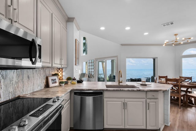 961 Northshore Dr, Miramar Beach, FL 32550 - kitchen with stainless steel appliances, light wood finished floors, recessed lighting, a peninsula, and light stone counters