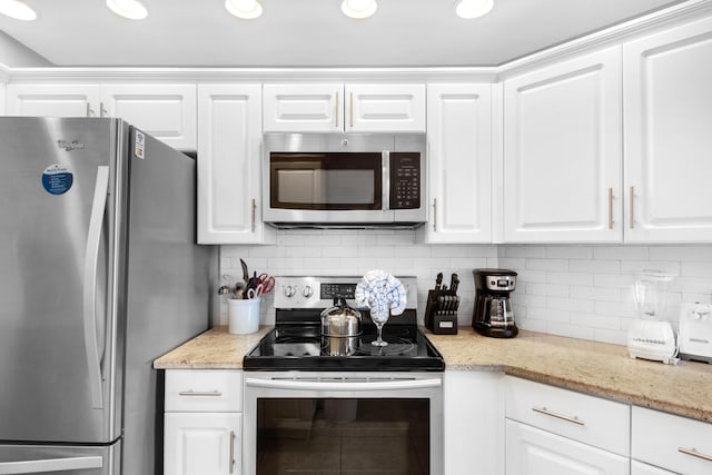 1096 Scenic Gulf Dr Unit 311, Miramar Beach, FL 32550 - kitchen with appliances with stainless steel finishes, white cabinetry, tasteful backsplash, and light stone counters