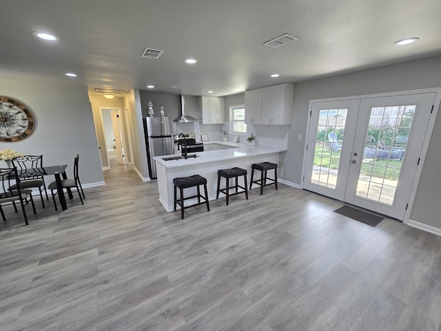 726 Clark Dr, Fort Walton Beach, FL 32547 - kitchen featuring wall chimney range hood, light countertops, recessed lighting, a peninsula, and a breakfast bar area