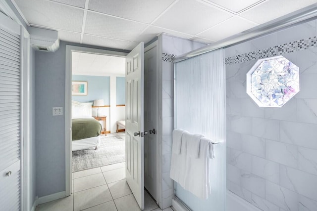 92 Tarpon St, Destin, FL 32541 - bathroom featuring a shower, a paneled ceiling, tile patterned flooring, and a wall mounted air conditioner
