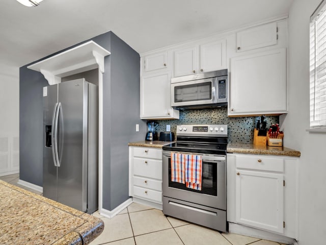 92 Tarpon St, Destin, FL 32541 - kitchen featuring stainless steel appliances, white cabinetry, decorative backsplash, and light tile patterned flooring