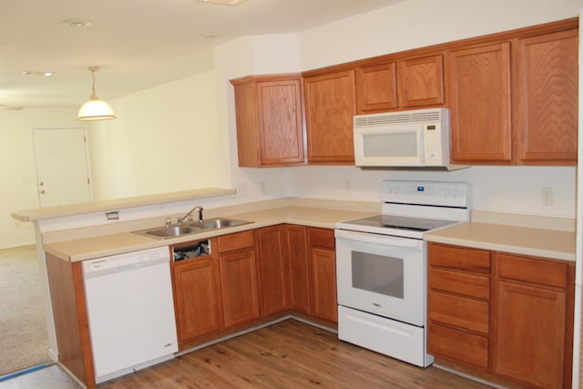 1802 Shay-Lin Ct, Niceville, FL 32578 - kitchen featuring white appliances, a peninsula, brown cabinets, light countertops, and decorative light fixtures