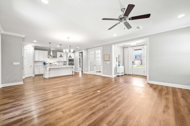 129 Meadow Lake Dr, Freeport, FL 32439 - unfurnished living room with ornamental molding, recessed lighting, a ceiling fan, light wood-style flooring, and a chandelier