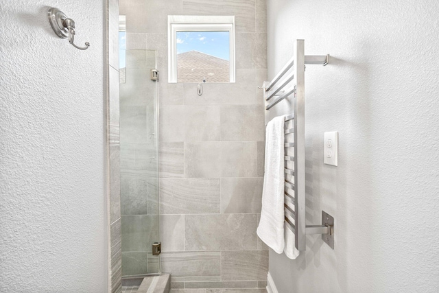 129 Meadow Lake Dr, Freeport, FL 32439 - bathroom with a towel warming rack, a tile shower, and a textured wall