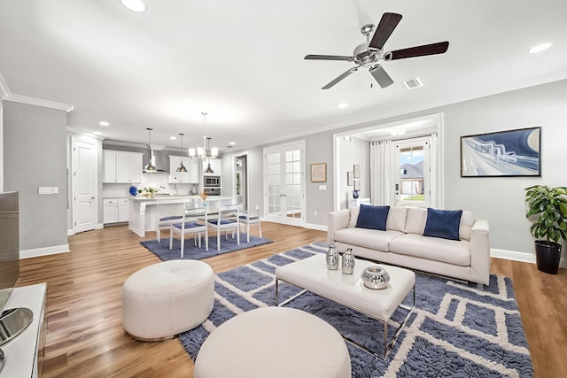 129 Meadow Lake Dr, Freeport, FL 32439 - living area with ornamental molding, recessed lighting, a ceiling fan, light wood finished floors, and a chandelier