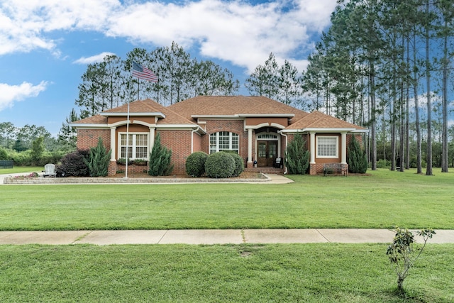 180 Gulf Pines Ct, Freeport, FL 32439 - view of front of house featuring a front lawn, brick siding, french doors, and a shingled roof