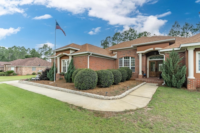 180 Gulf Pines Ct, Freeport, FL 32439 - view of front of property featuring french doors, brick siding, a front yard, and roof with shingles