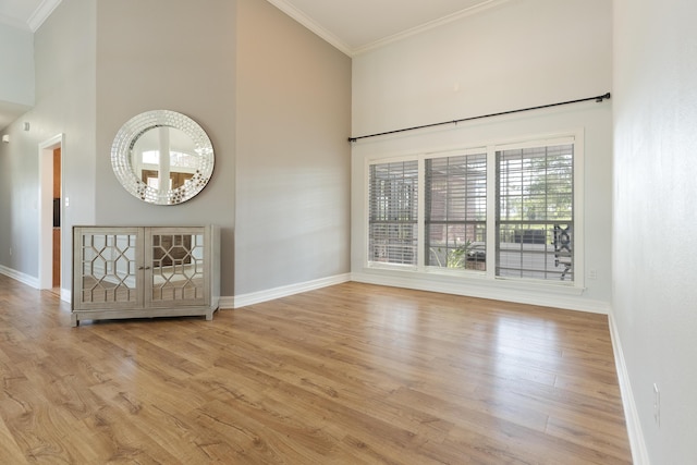 180 Gulf Pines Ct, Freeport, FL 32439 - spare room featuring crown molding, light wood-type flooring, and a towering ceiling