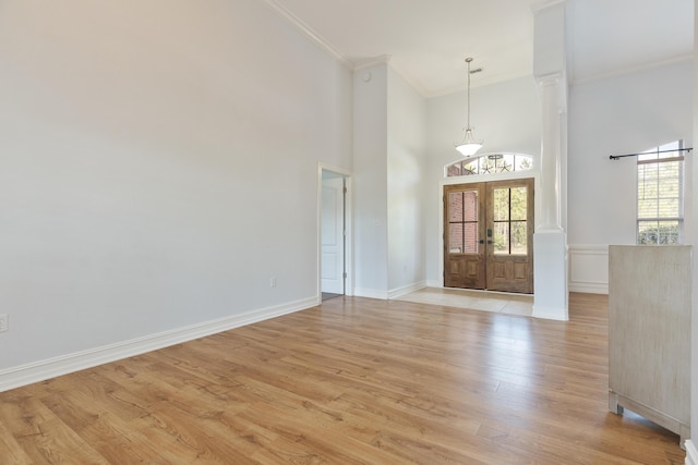 180 Gulf Pines Ct, Freeport, FL 32439 - empty room featuring ornamental molding, plenty of natural light, french doors, light wood finished floors, and a towering ceiling