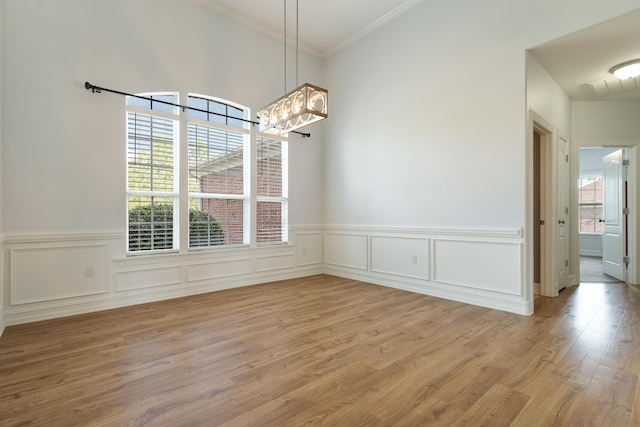 180 Gulf Pines Ct, Freeport, FL 32439 - unfurnished dining area featuring a chandelier, light wood-style floors, ornamental molding, and wainscoting