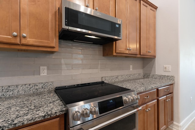 180 Gulf Pines Ct, Freeport, FL 32439 - kitchen featuring appliances with stainless steel finishes, decorative backsplash, light stone counters, and brown cabinetry