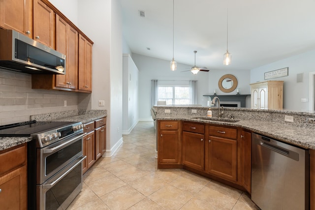 180 Gulf Pines Ct, Freeport, FL 32439 - kitchen featuring appliances with stainless steel finishes, brown cabinets, decorative backsplash, ceiling fan, and pendant lighting