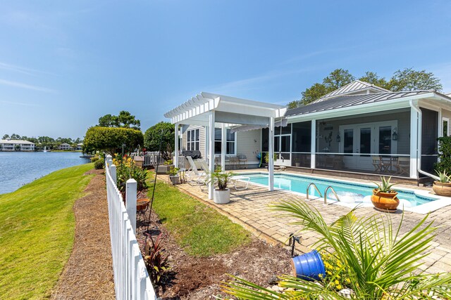 2077 Olde Towne Ave, Miramar Beach, FL 32550 - back of house featuring a sunroom, a patio, a standing seam roof, an outdoor pool, and a water view
