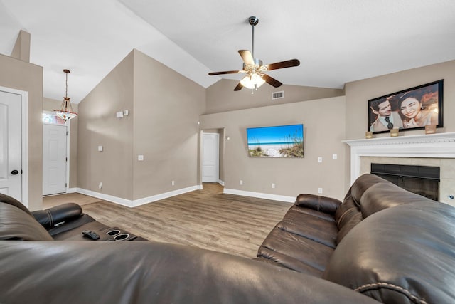 653 Territory Ln, Crestview, FL 32536 - living room featuring a ceiling fan, wood finished floors, a tiled fireplace, and high vaulted ceiling