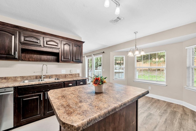 653 Territory Ln, Crestview, FL 32536 - kitchen featuring stainless steel dishwasher, dark brown cabinets, pendant lighting, light wood finished floors, and a center island