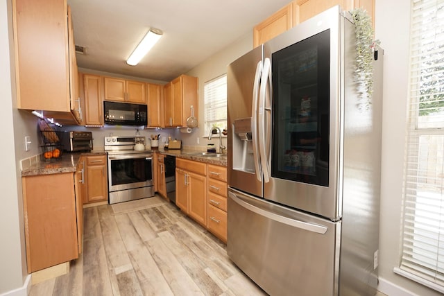 52 NE Iowa Dr, Fort Walton Beach, FL 32548 - kitchen featuring black appliances, light wood-style floors, light brown cabinets, and dark countertops