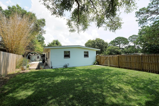 52 NE Iowa Dr, Fort Walton Beach, FL 32548 - rear view of house with a fenced backyard and a storage unit
