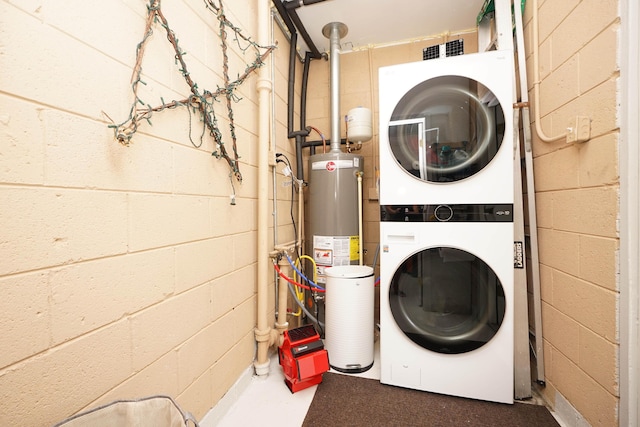52 NE Iowa Dr, Fort Walton Beach, FL 32548 - washroom with estacked washer and dryer, water heater, and concrete block wall